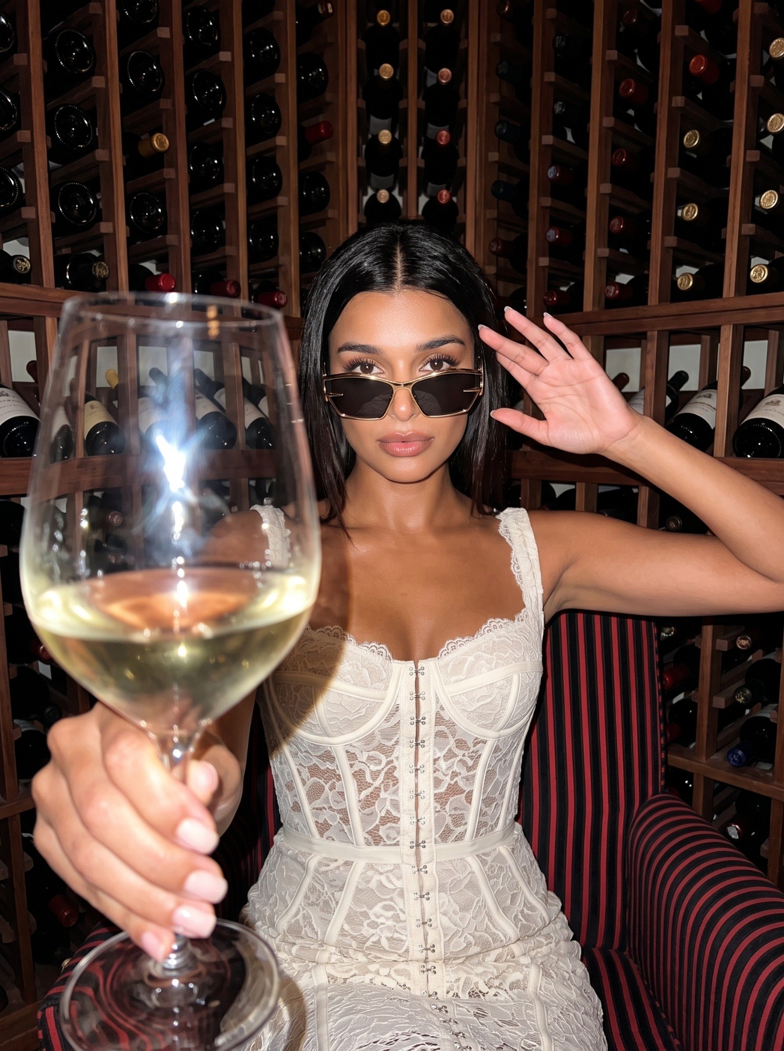 Sofia Whitmore wearing AXIS 01 sunglasses in a wine room