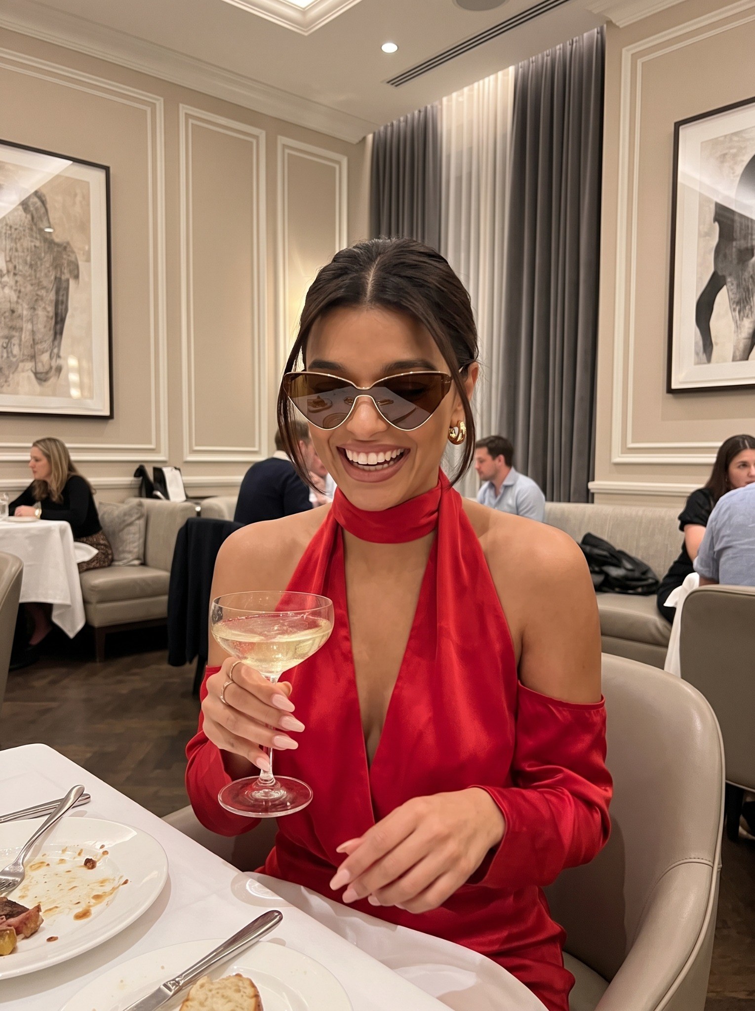 Sofia Whitmore wearing NOCTURNE 01 sunglasses at dinner in a red dress